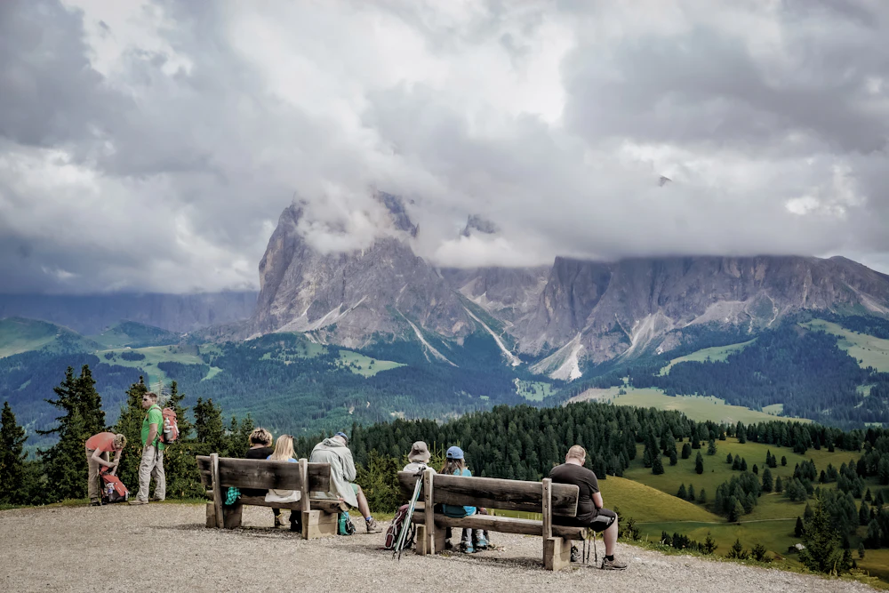 Walkers pause to take in the mountain scenery at Alpe di Siusi